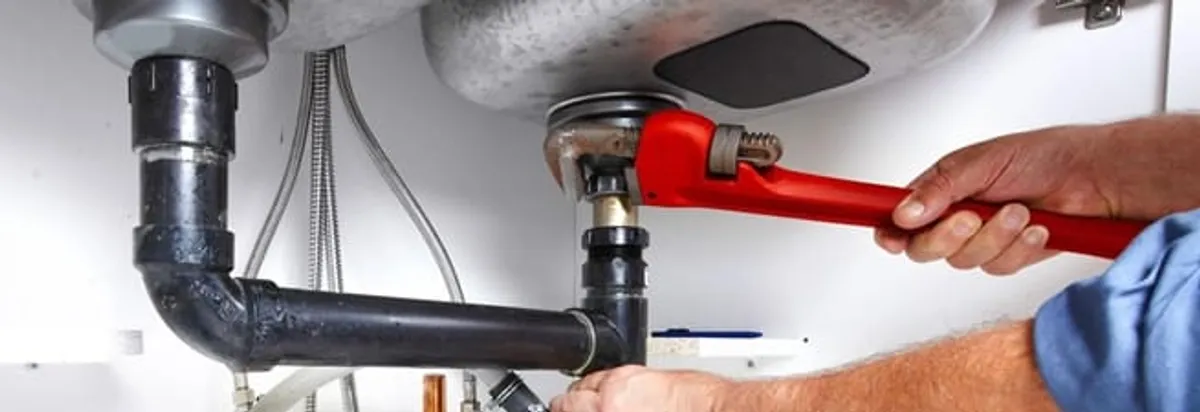 Garbage disposal repair technician tightening the sink drain and disposal connection in Sioux Falls, SD
