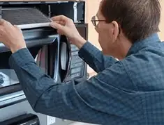 Appliance repair technician replacing a microwave vent filter in Sioux Falls, SD