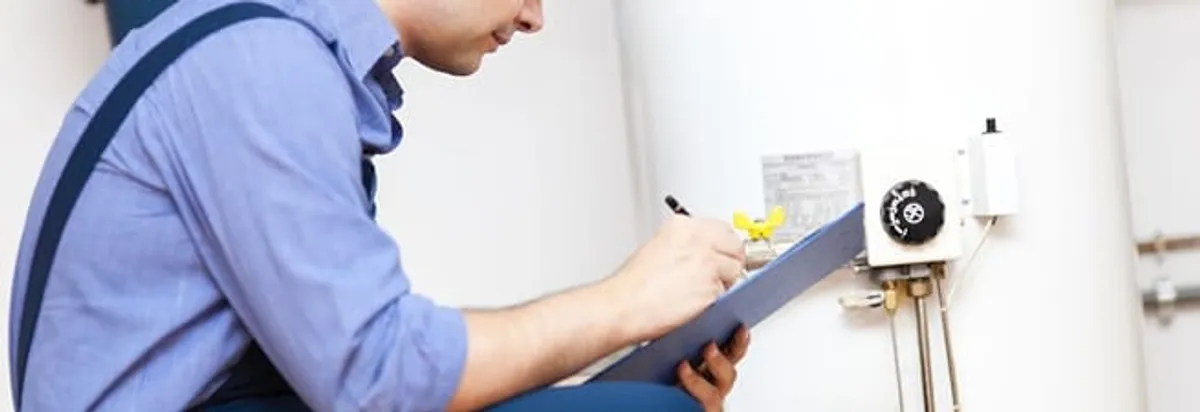 Water heater repair technician inspecting the unit and recording service notes in Sioux Falls, SD